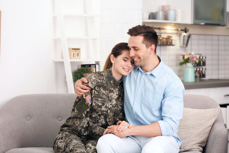 Woman in military uniform with husband on sofa at home royalty free stock images Woman in military uniform with husband on sofa at home royalty free stock images