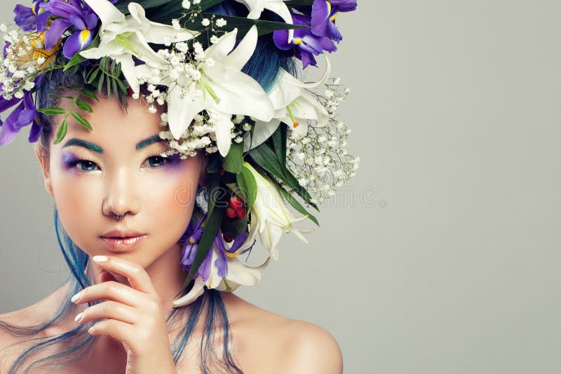 Woman modèle asiatique parfait avec les fleurs vives et le maquillage de mode photographie stock libre de droits Woman modèle asiatique parfait avec les fleurs vives et le maquillage de mode photographie stock libre de droits