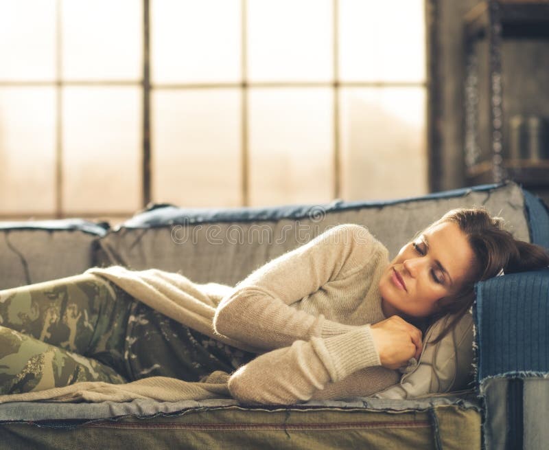 Woman napping on a sofa in a city loft