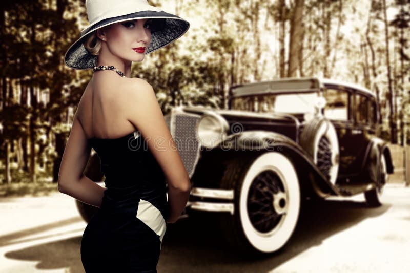 Woman in nice dress and hat against retro car