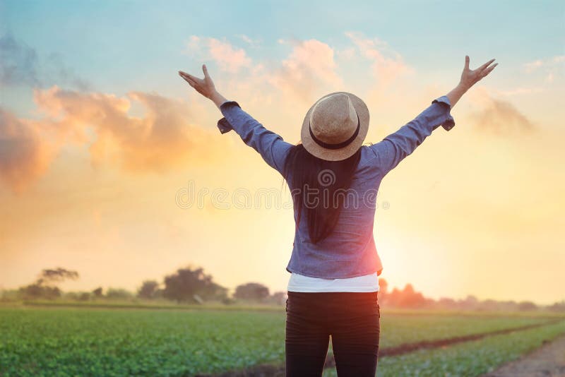 Woman open arms breath of fresh air under the sunset at meadow