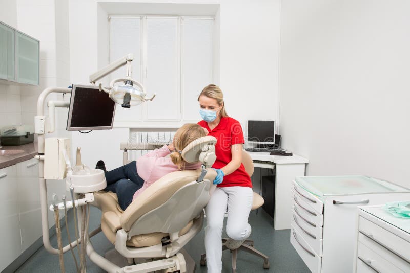 Woman with open mouth having her teeth examined by female dentist. Teeth checkup at dentist`s office. stock photos Woman with open mouth having her teeth examined by female dentist. Teeth checkup at dentist`s office. stock photos