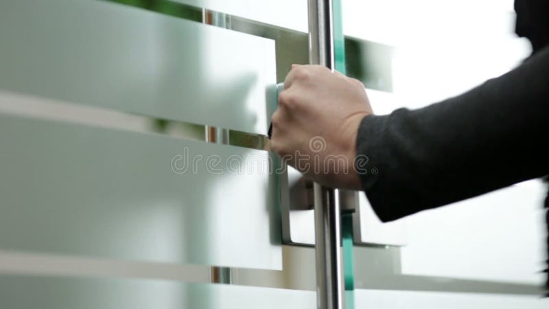 Woman opening glass door to office