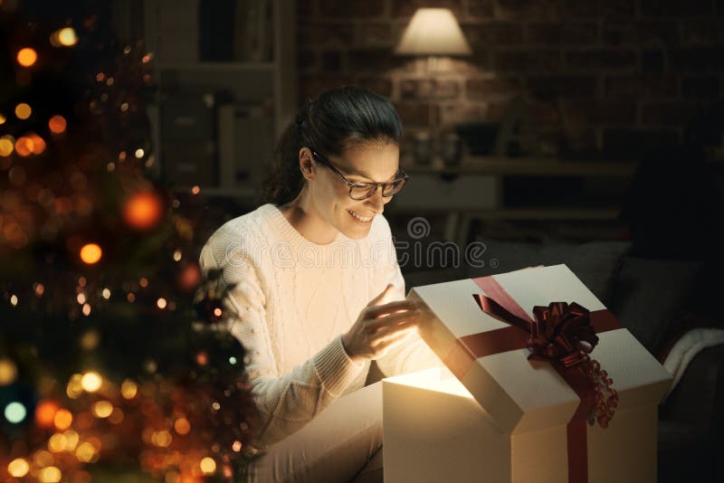 Woman opening a magical Christmas gift stock photo Woman opening a magical Christmas gift stock photo
