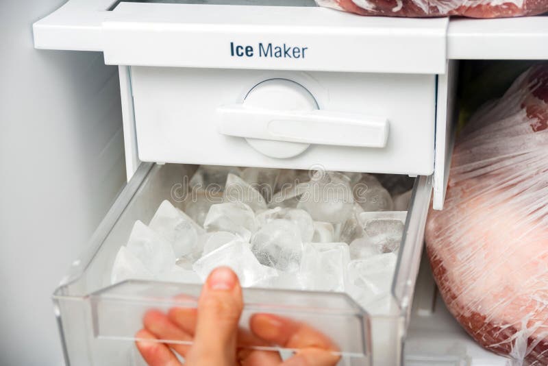 A Woman Opens an Ice Maker Tray in the Freezer To Take Ice Cubes