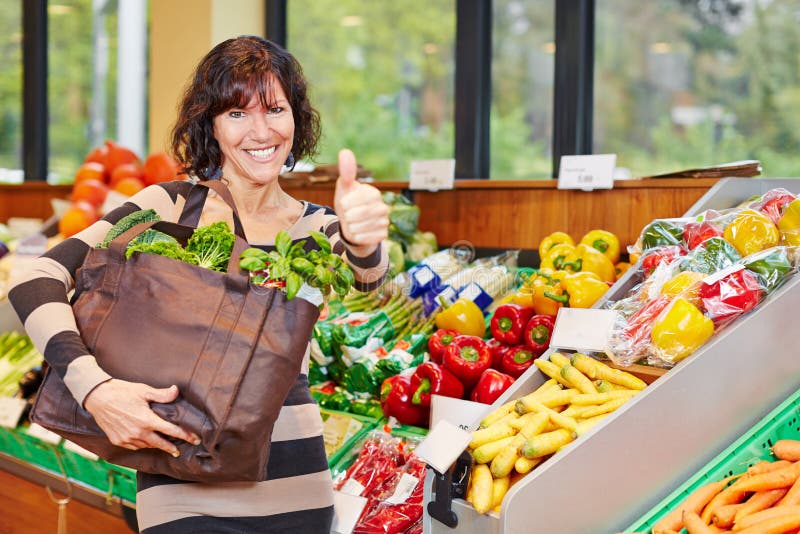 Woman in organic food store holding stock photos Woman in organic food store holding stock photos