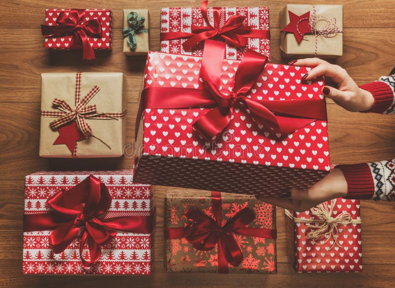 Woman organising beautifully wrapped vintage christmas presents, image with haze, view from above stock images