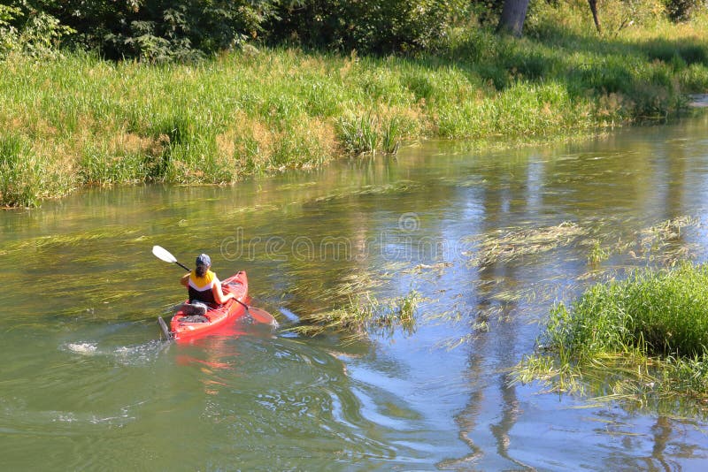 Woman Paddles Kayak on Winding Stream royalty free stock photos Woman Paddles Kayak on Winding Stream royalty free stock photos