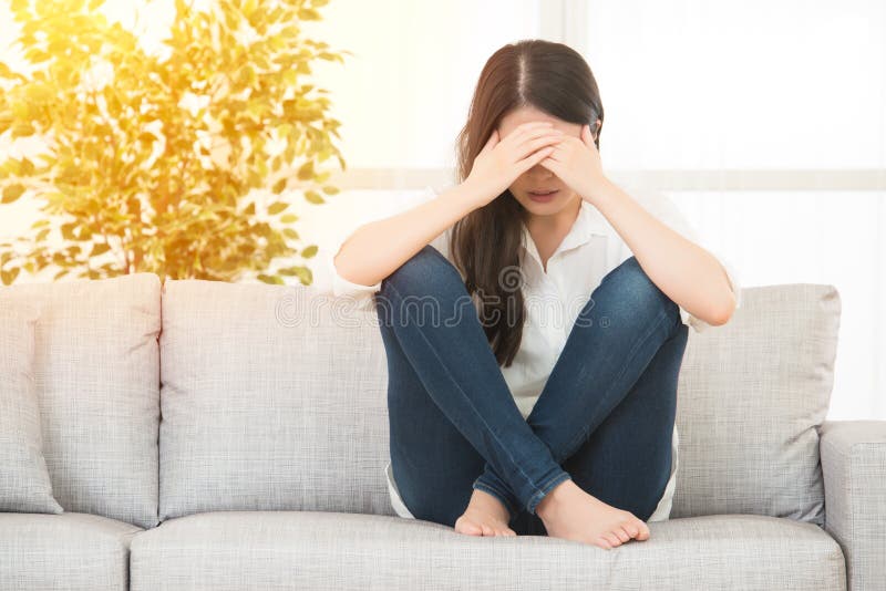 Woman painful expression suffering menstrual period. Young beautiful woman in painful expression suffering menstrual period pain on sofa couch having tummy cramp stock photos Woman painful expression suffering menstrual period. Young beautiful woman in painful expression suffering menstrual period pain on sofa couch having tummy cramp stock photos