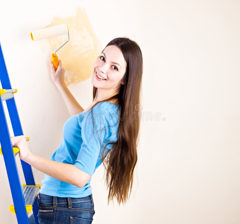 A woman is painting walls