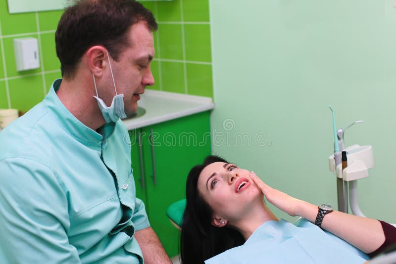 Woman patient talking to male dentist and complain of toothache at dental clinic office stock photos Woman patient talking to male dentist and complain of toothache at dental clinic office stock photos
