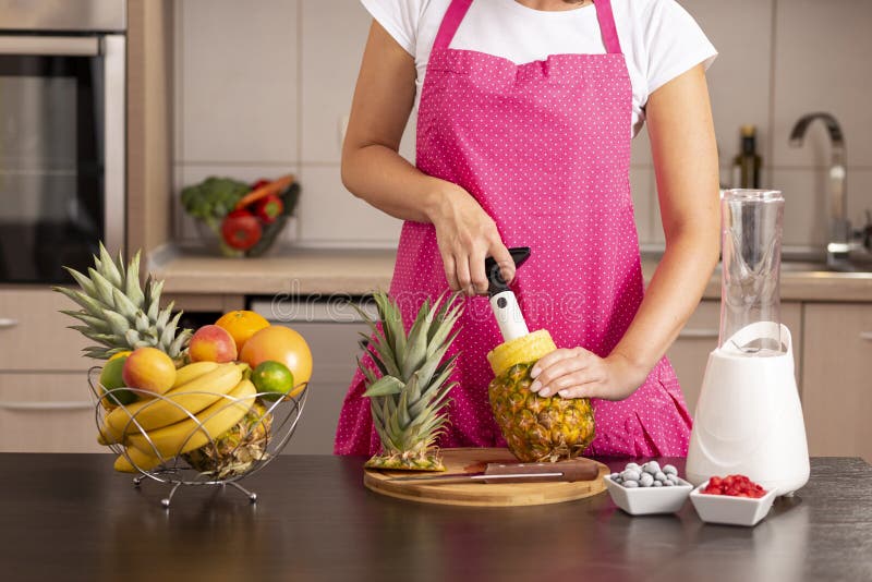 Woman using a pineapple cutter stock image Woman using a pineapple cutter stock image
