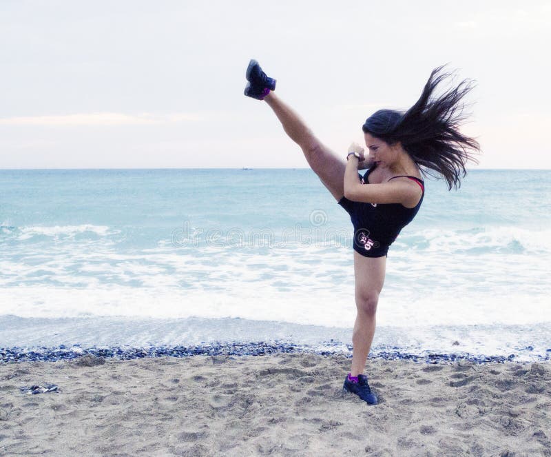 Woman performing a high kick stock image