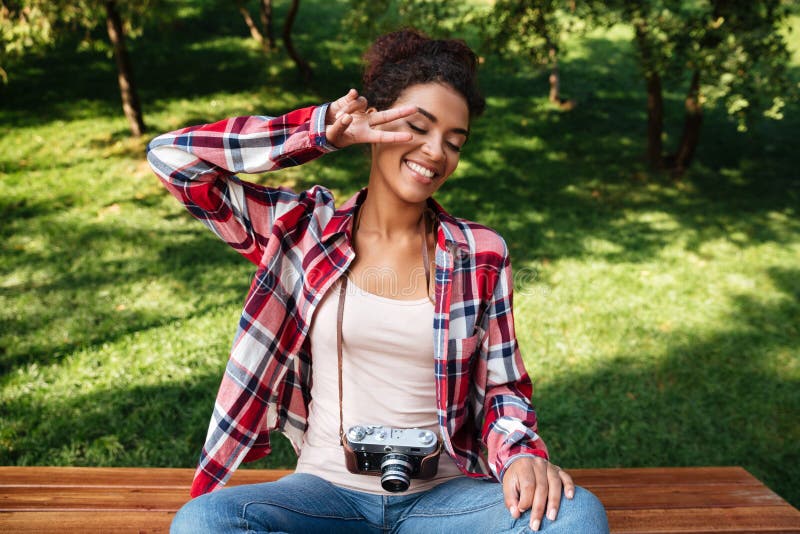 Woman photographer sitting outdoors in park. stock photo Woman photographer sitting outdoors in park. stock photo