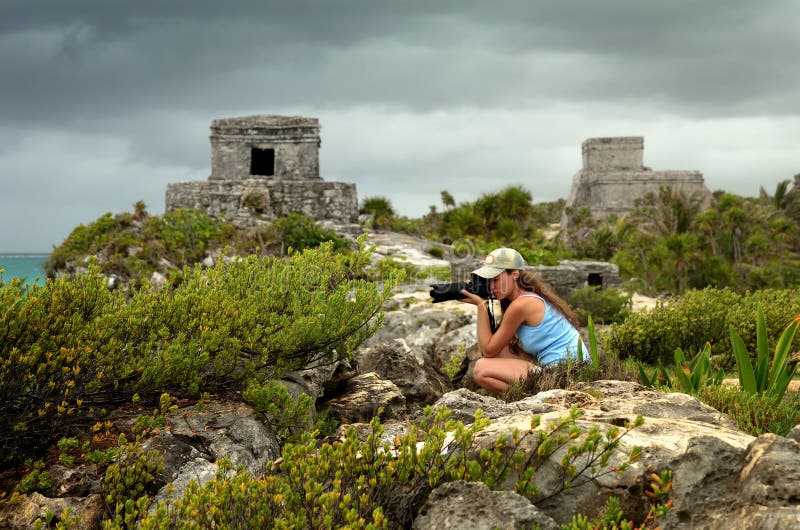 Žena fotografovanie Karibskom pobreží pred dažďom proti strážna Veža v starobylého mesta Tulum, Mexiko.