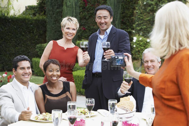 Woman Photographing Friends At Dinner Party stock photos Woman Photographing Friends At Dinner Party stock photos