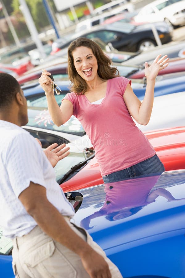 Woman picking up keys to new car from lot