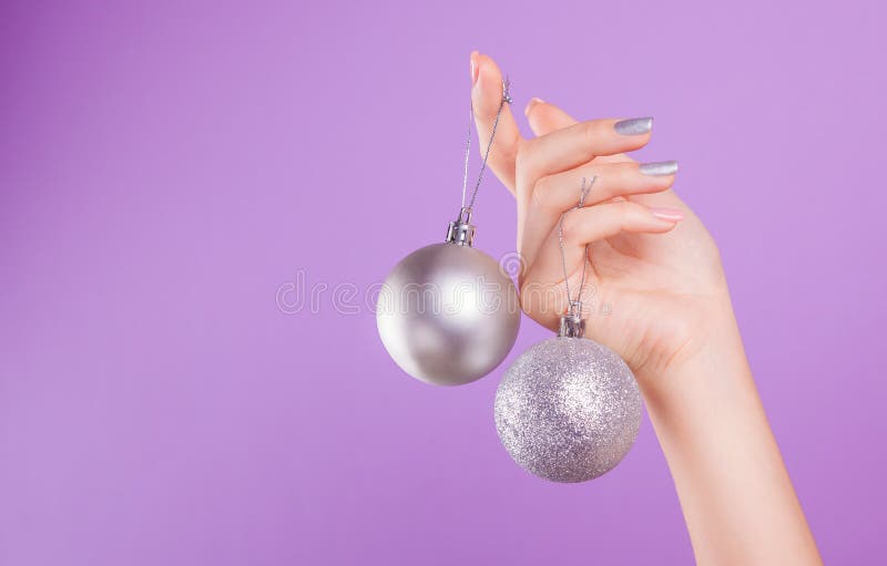 Woman with pink and silver manicure holds silver Christmas balls stock images Woman with pink and silver manicure holds silver Christmas balls stock images