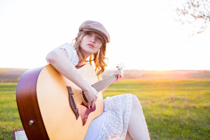 Woman playing acoustic guitar in park stock photos Woman playing acoustic guitar in park stock photos