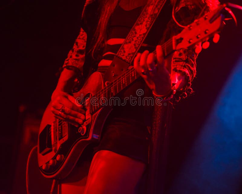 Woman playing electric guitar on stage during a concert