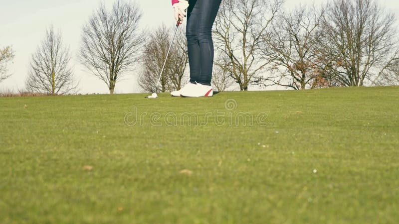 Woman playing golf lining up a putt