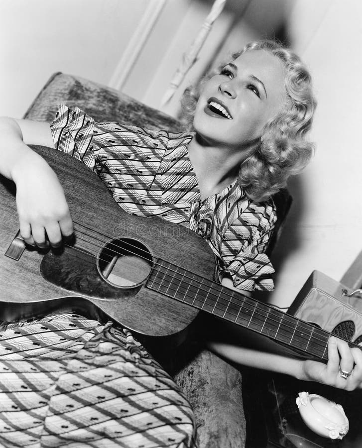 Woman playing guitar and singing (All persons depicted are no longer living and no estate exists. Supplier grants that there will be no model release issues.)