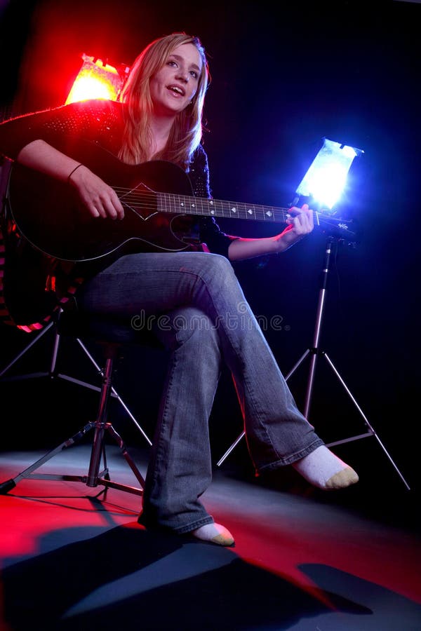 Woman playing guitar on stage