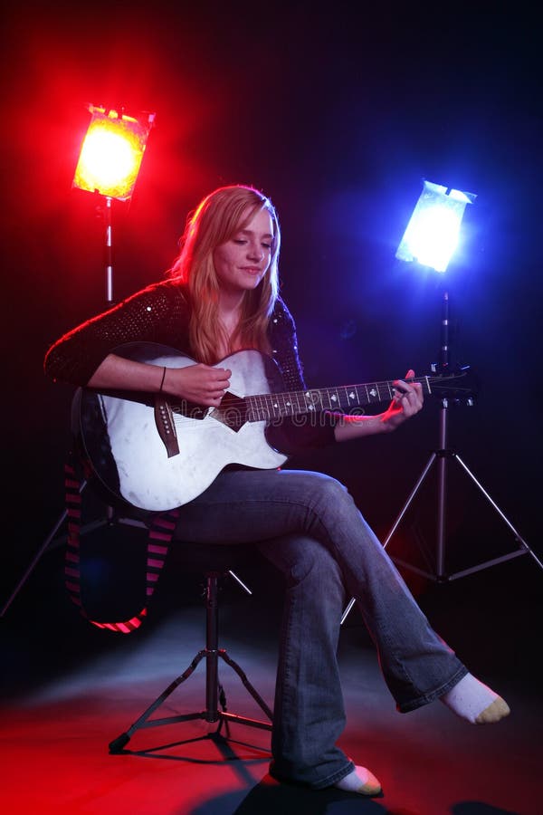 Woman playing guitar on stage