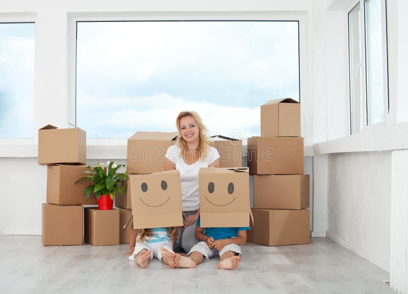 Woman with playing kids in their new home having fun among cardboard boxes