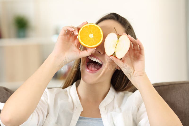 Woman playing with an orange and apple