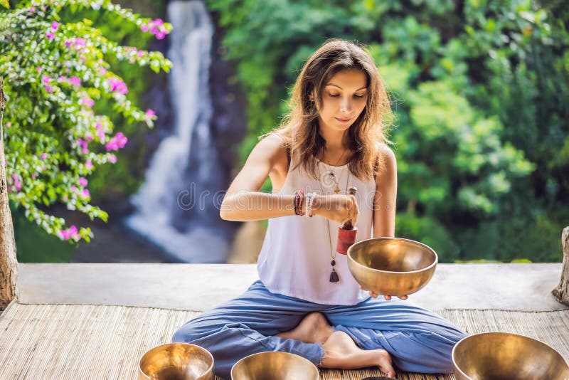 Woman Playing On Tibetan Singing Bowl While Sitting On Yoga Mat Against A Waterfall Vintage Tonned Beautiful Girl With Stock Photo Image Of Meditation Bowl