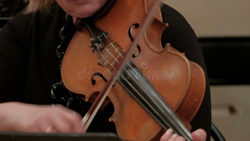 A woman plays a beautiful violin music. Close-up female violinist hands.