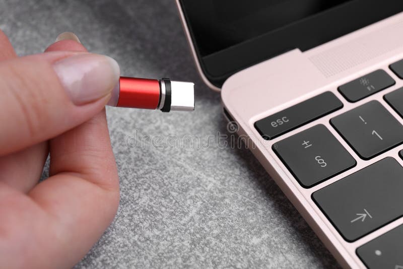 Woman Plugging USB Cable with Type C Connector into Laptop Port at Grey