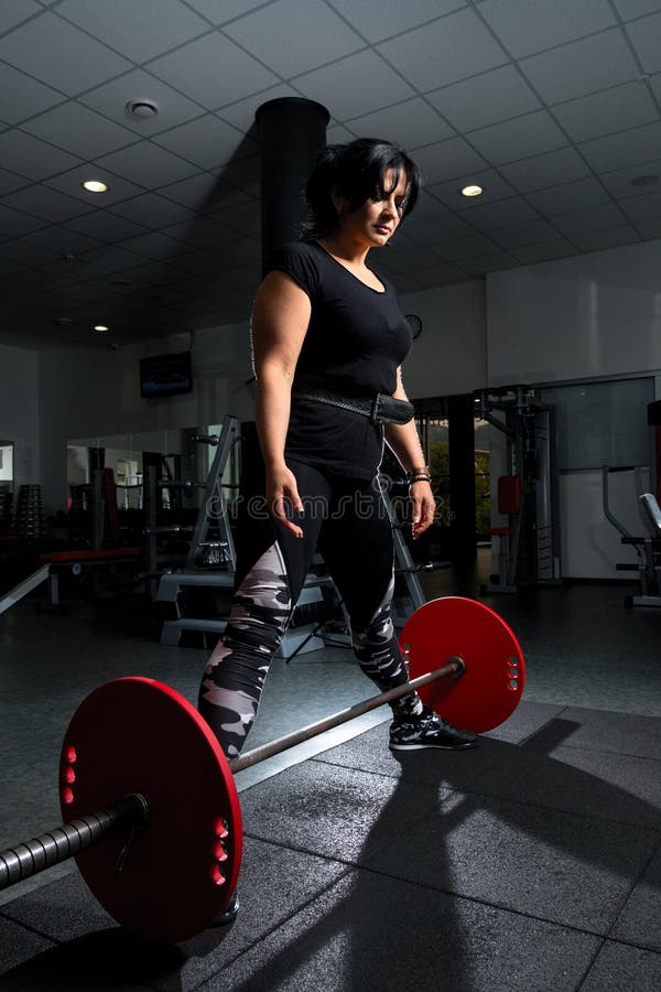 Woman Plus Size in Gym Doing Exercises with Barbell Powerlift, F