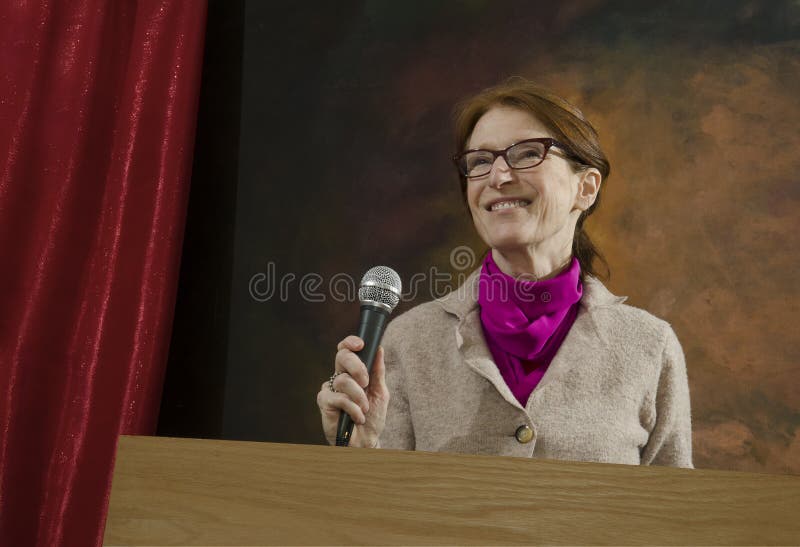 Woman at podium with microphone stock photo Woman at podium with microphone stock photo