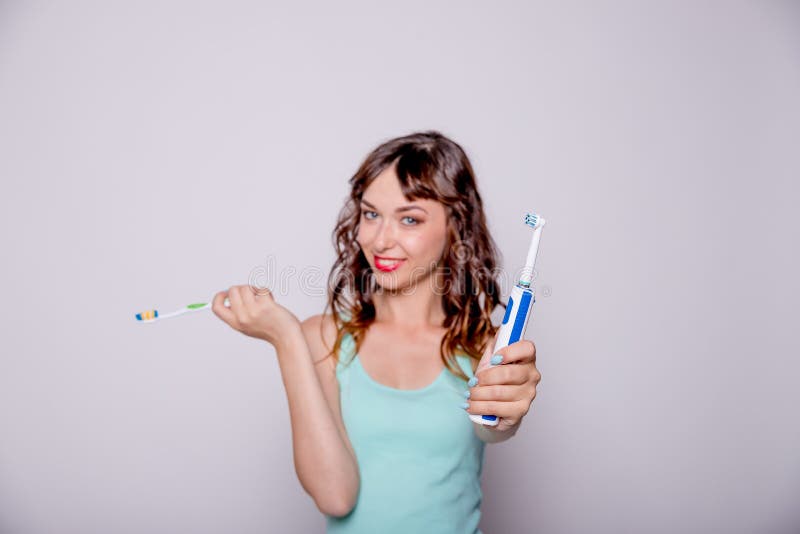 Woman giving me electric toothbrush. Selective focus.Happy woman cleaning her oral cavity caring about dental health