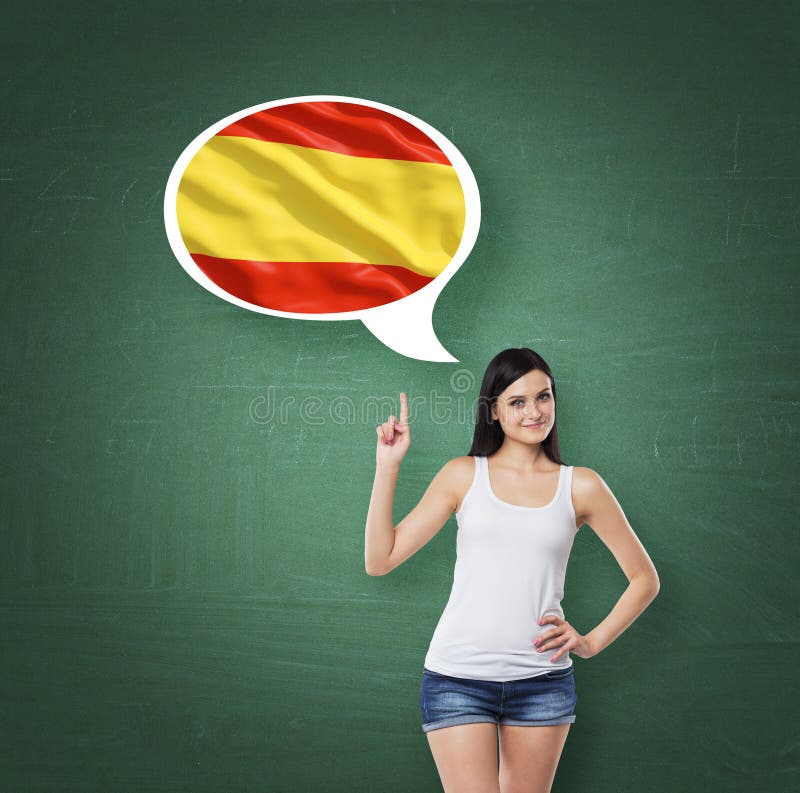 Woman is pointing out the thought bubble with Spanish flag. Green chalk board background.