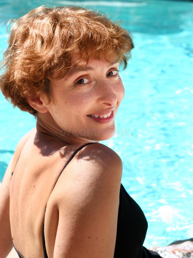 Bella donna matura, sorridente con la piscina.