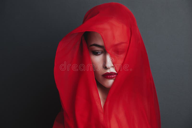 Woman portrait cover with red veil studio shot stock photography
