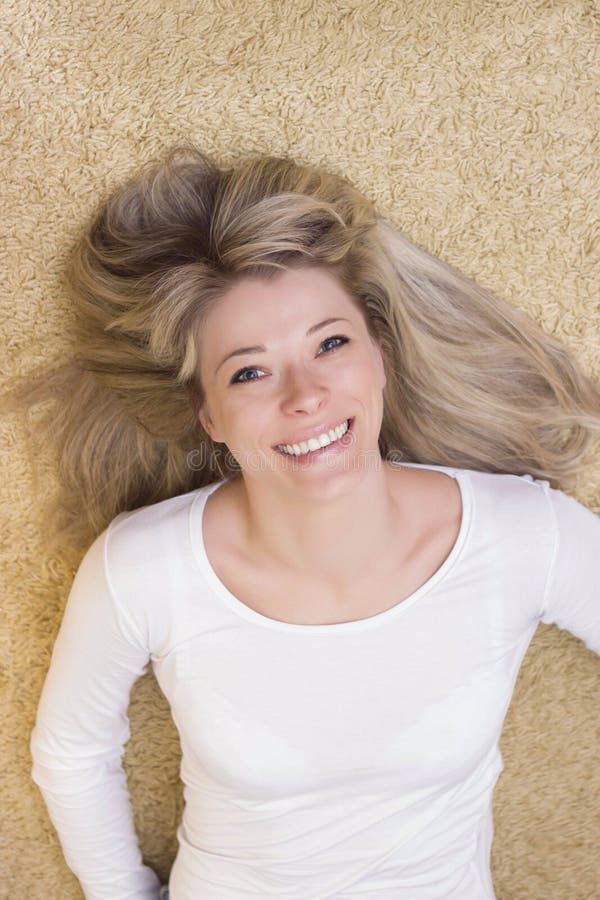 Woman portrait lying on the floor and smiling stock photo Woman portrait lying on the floor and smiling stock photo
