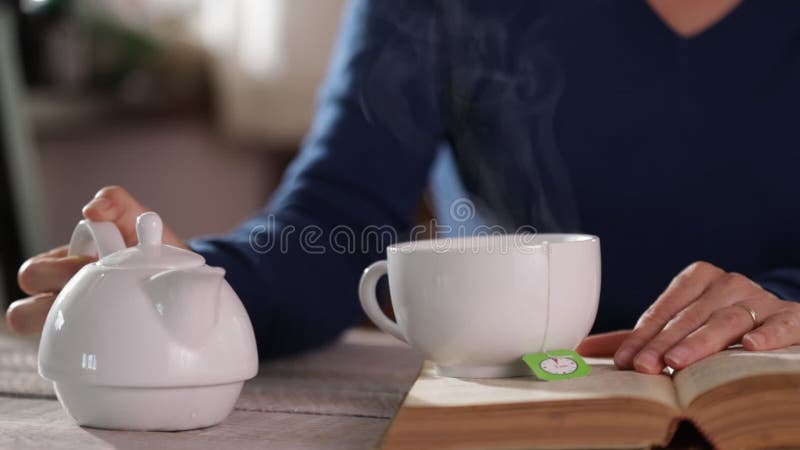 Woman making tea, steam rising in the sunlight