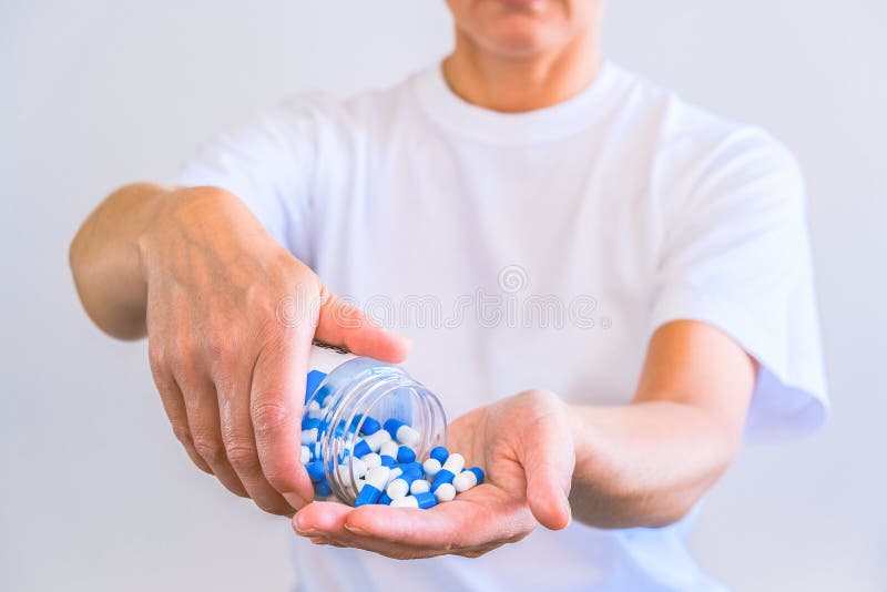 The woman poured a handful of sports capsules into the palm of her hand. Reception before training. Increase strength and energy. Fat burning and weight loss.