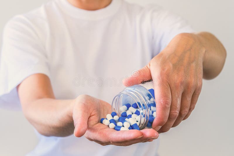 The woman poured a handful of sports capsules into the palm of her hand. Reception before training. Increase strength and energy. Fat burning and weight loss.