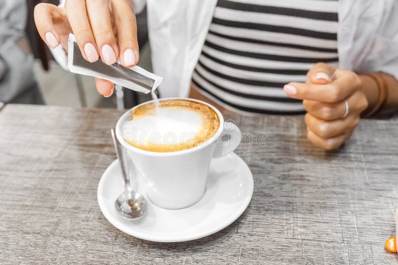 Woman pouring sugar and preparing hot coffee cup