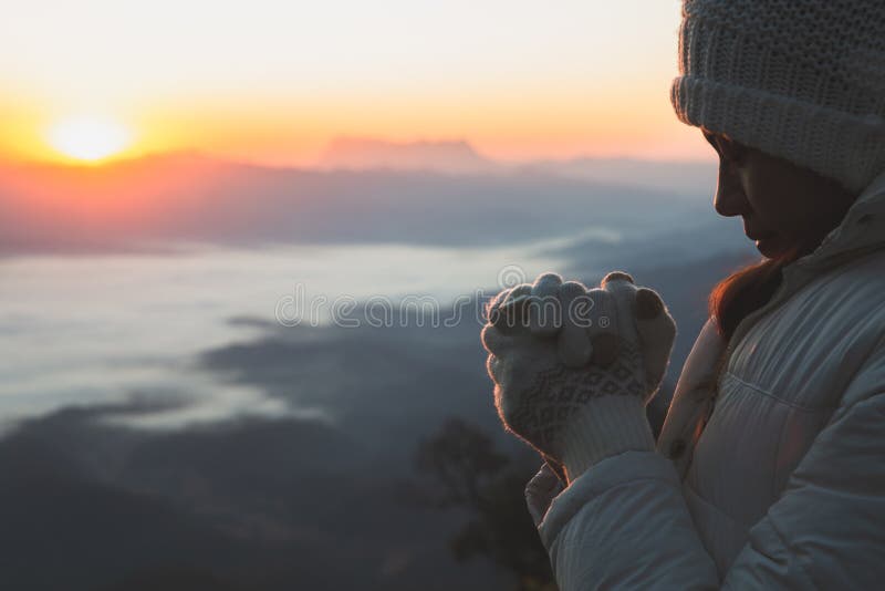 A women is praying to God on the mountain. Praying hands with faith in religion and belief in God on blessing background. Power of