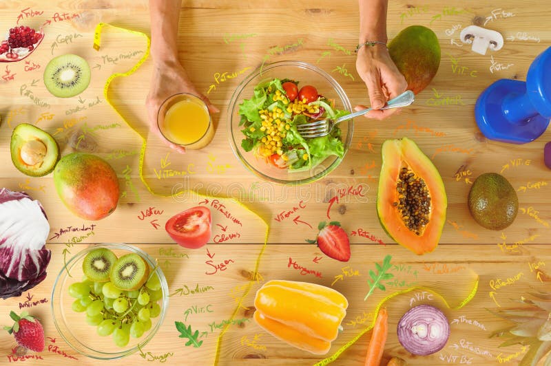 Woman Prepares A Healthy Meal With Salad And Orange Juice Stock Photo woman-prepares-a-healthy-meal-with-salad-and-orange-juice-stock-photo