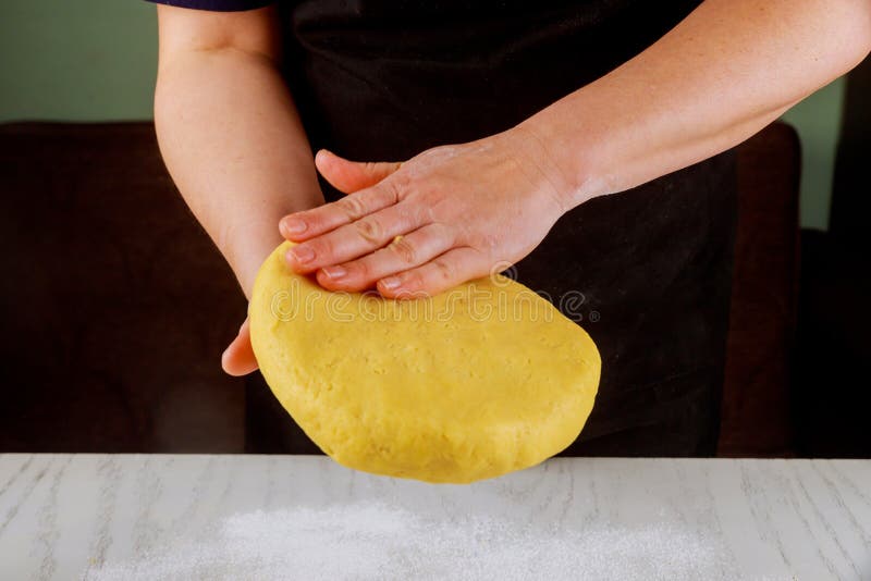A woman presses on dough for making cookies