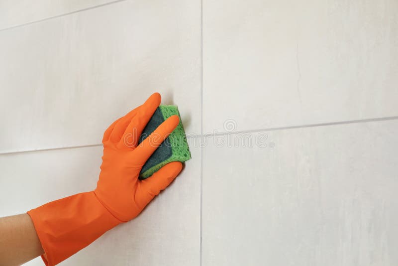 Woman in protective glove cleaning bathroom wall with sponge stock photography Woman in protective glove cleaning bathroom wall with sponge stock photography