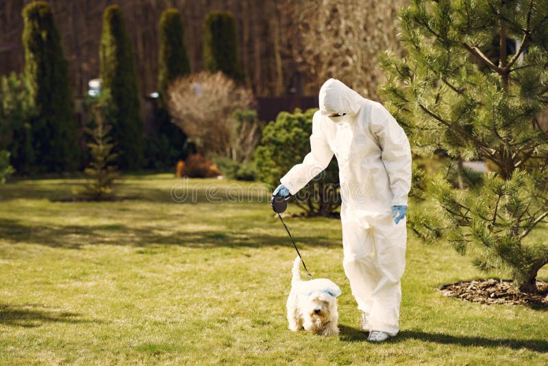 Woman in a protective suit walking with a dog