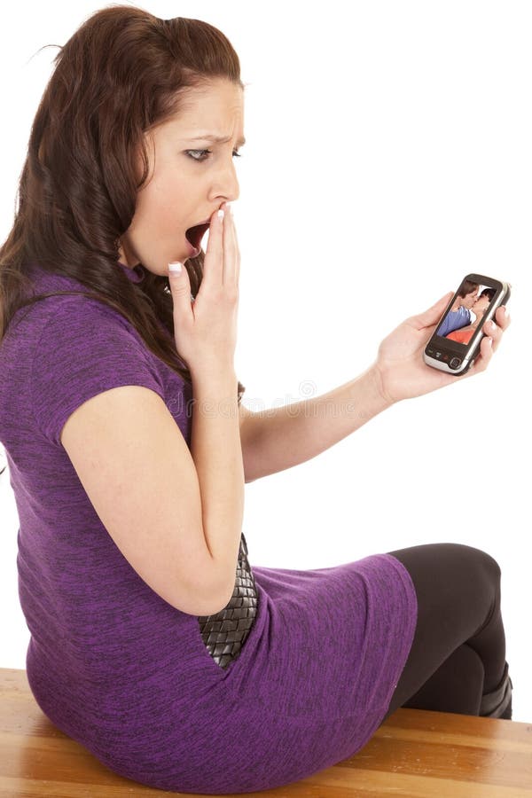 Woman in purple back shocked at phone screen